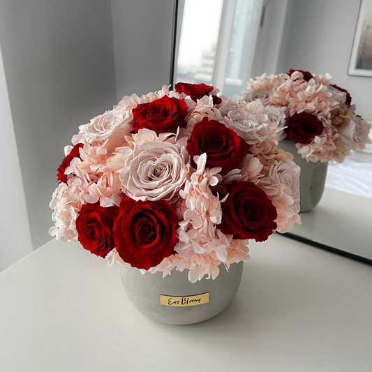 The Pixie by Eos Blooms: preserved roses in a round stone vase, mirrored beautifully.