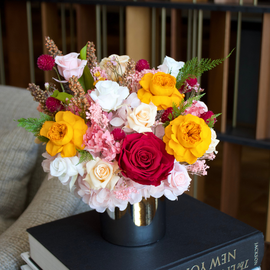 The Reverie (Petite) by Eos Blooms: preserved flowers in a vase on stacked books.