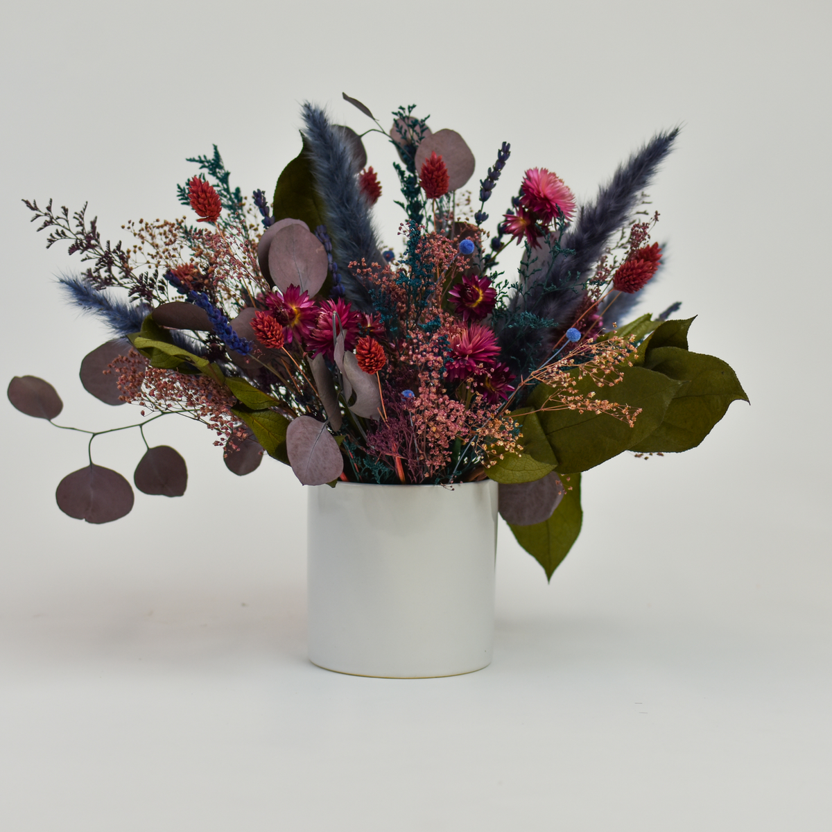 Tropics by Eos Blooms: modern preserved bouquet in a white vase against a plain background.
