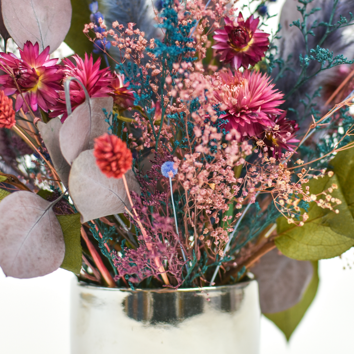 Tropics by Eos Blooms: preserved Forever Flowers in a silver vase on a white background.
