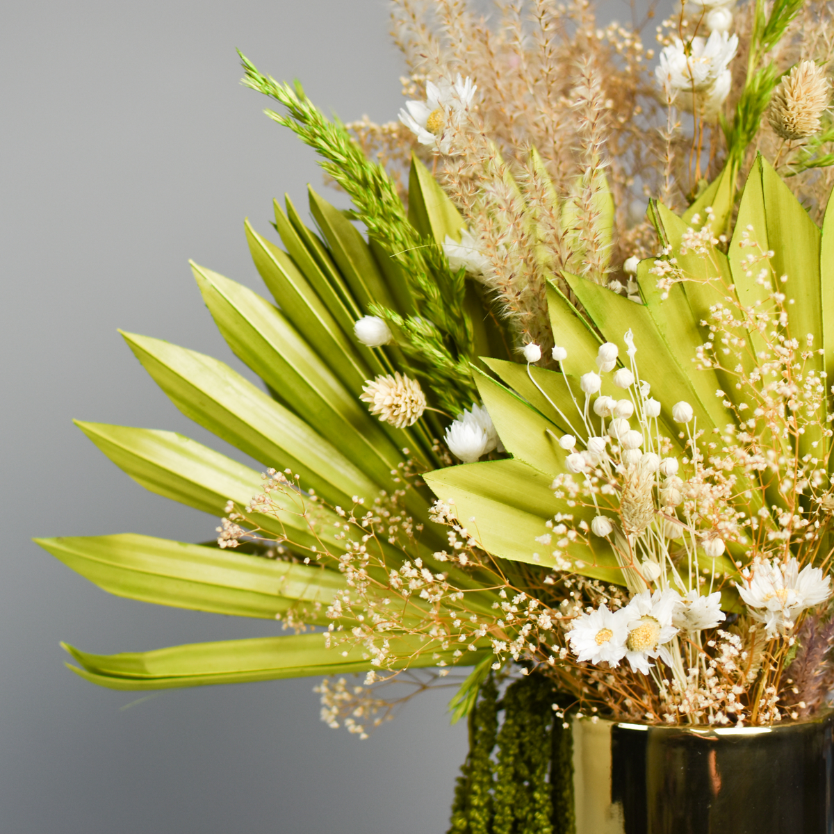 Thrive - Premium by Eos Blooms: Preserved flowers and greens in a gold vase against gray.