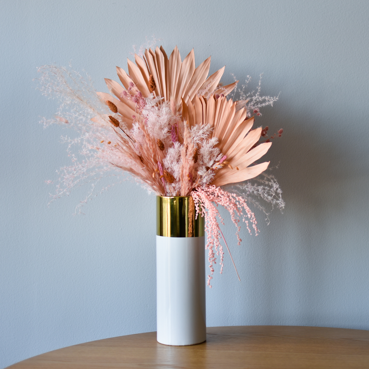 The Dune - Premium by Eos Blooms features preserved flowers in a white and gold vase.