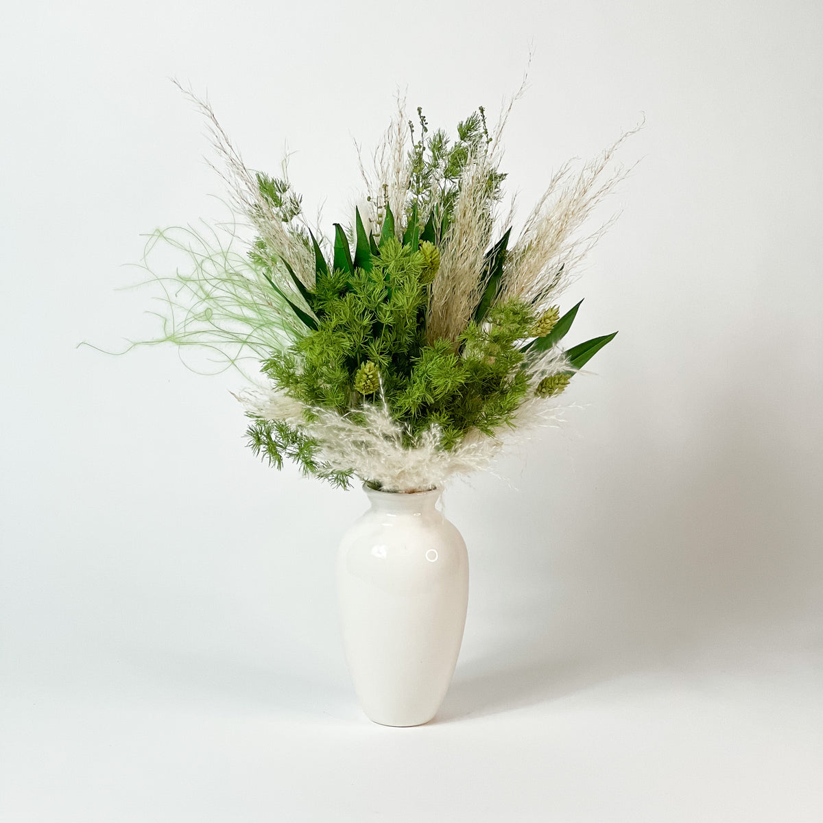 Eos Blooms Botanical: white vase with greenery and pampas, ideal for plant enthusiasts.