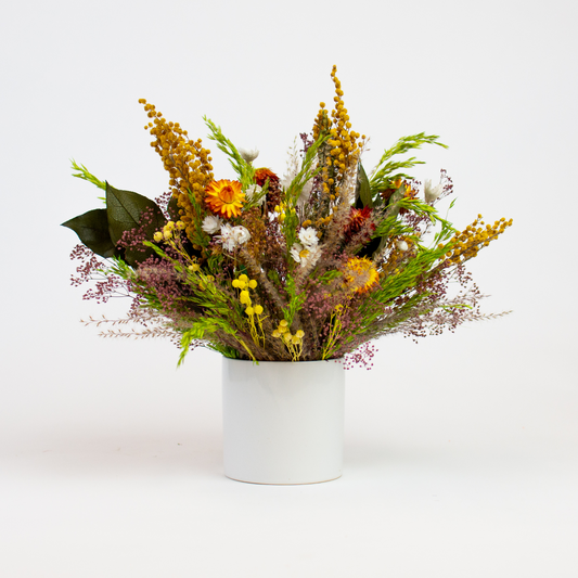Meadow by Eos Blooms: assorted wildflowers in a white vase on a plain white background.