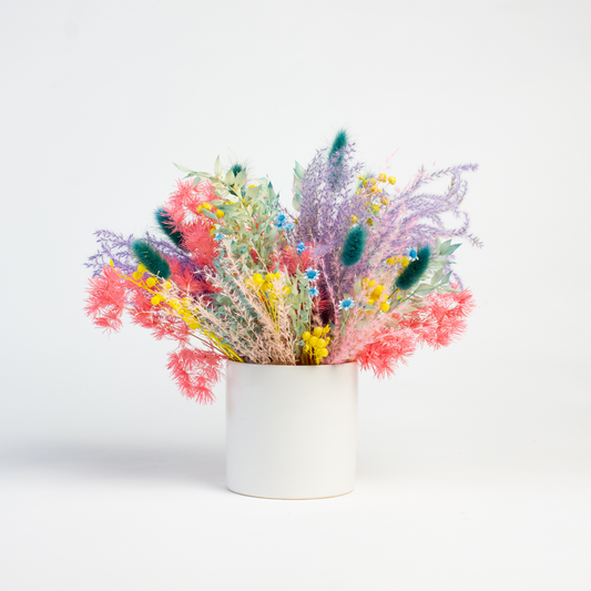 Eos Blooms Prism: Colorful preserved flowers in a white vase on a white background.